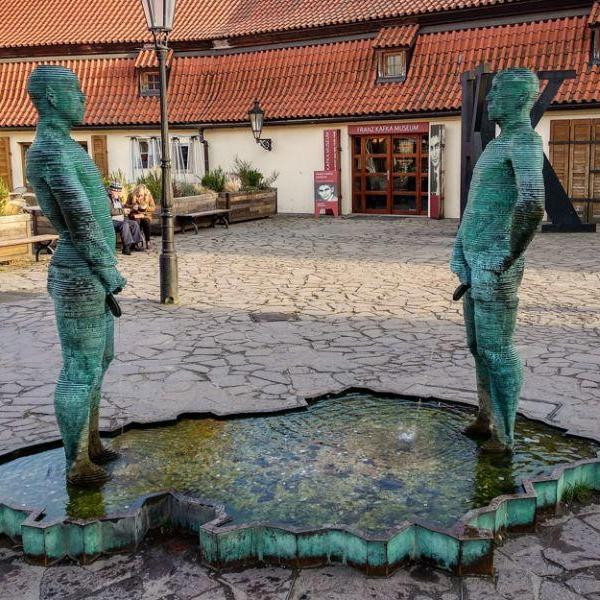 Где установлена статуя из двух писающих мужчин, которые пишут струями воды разные цитаты?